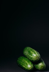 green cucumbers on a black background