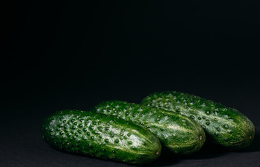 green cucumbers on a black background