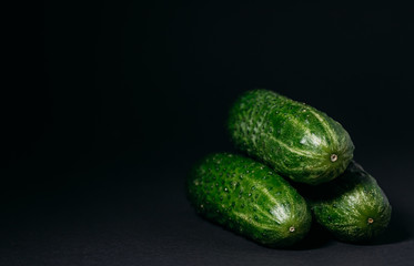 green cucumbers on a black background