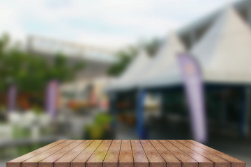 Empty wooden table top with lights bokeh on blur restaurant background, 3D Rendering