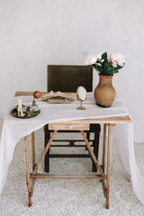 Romantic dressing table with a bouquet of peonies in a vase and a mirror. Bedroom interior in the vintage style. Boudoir. 
