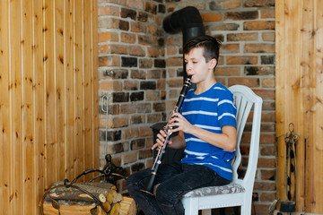 Boy with a clarinet plays music. Online music lesson concept