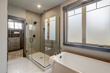 Natural new classic bathroom interior with new glass walk in shower, white tub and walk in closet. - obrazy, fototapety, plakaty