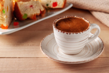 Cup of fresh aromatic coffee with homemade cakes on a wooden table