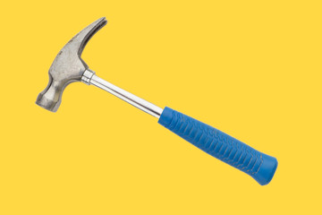 Blue hammer on yellow background. Selective focus