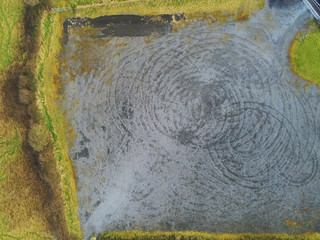 Aerial drone view on a small gravel parking lot with round car tracks after drift. Concept car...