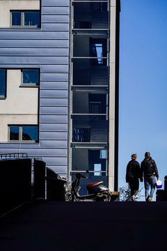 Stockholm, Sweden A couple walk hand in hand in silhouette in Kvarnholmen, a newly refurbished residential section of town.