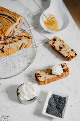 Butter-free, sugar-free banana bread with oat flour, soft curd cheese and honey. Top view of sliced banana bread on gray marble background. Ideas and recipes for healthy diet breakfast