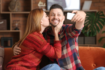 Happy couple taking selfie at home