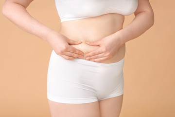 Overweight woman on color background, closeup. Weight loss concept