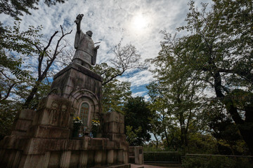 Fototapeta premium 池上本門寺の日蓮大上人説法像。太陽が入った斜めからの画。池上本門寺は東京都大田区にある鎌倉時代からの寺院。