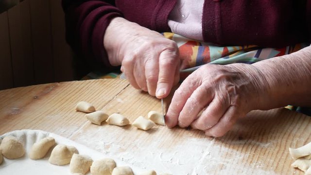hands of elderly woman making homemade pasta orecchiette. typical food of southern Italy
