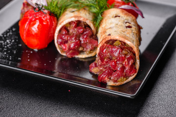 Delicious fresh beef tartar with toasts on a black square plate