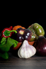 composition with vegetables: red onion, garlic, purple tomato, green tomato, red tomato and red pepper