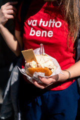 Young woman, tourist holding gelato or ice cream in brioche traditional Sicilian street food dessert in Palermo, Sicily, Italy.