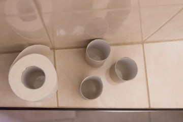 paper roll of toilet paper. next to it are empty bushings from the finished roll. Concept of diarrhea, intestinal disorders.