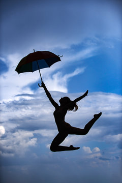 Woman jumping with umbrella. Ballet dancer isolated on sky background. Expressive artistic dance concept. Woman jump silhouette. Umbrella woman jump and sunset silhouette.