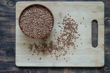 Buckwheat cereal in a wooden cup, on a wooden board