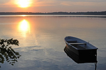 Ein Boot liegt auf einem See zum Sonnenaufgang