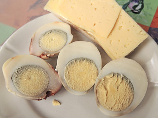 boiled egg in a composition with cheese and mayonnaise on a white plate.