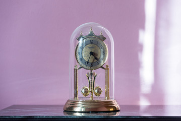 Mantel Clock with Glass Dome & Rotating Pendulum. Period clock with oscillating mechanism on an old...