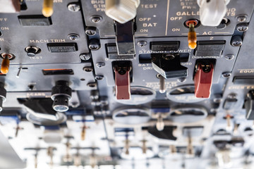 Closeup view of many switches in an aircraft cockpit with shallow focus