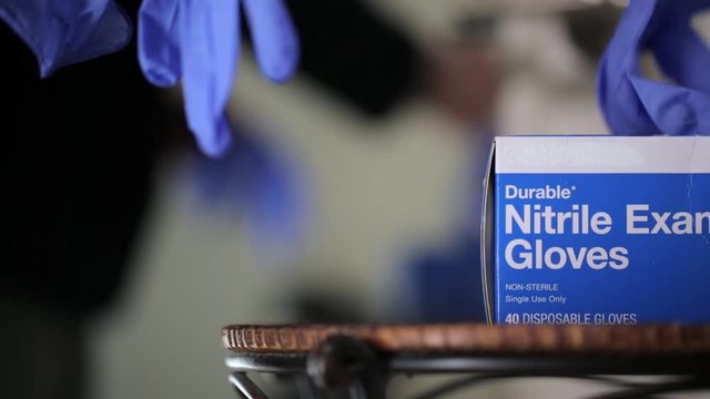 man removing safety medical gloves before leaving house during coronavirus COVID-19 pandemic