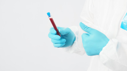 Male model with PPE suite and Hand with glove is holding blood tube on white background.