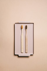 Zero waste. Wooden bamboo toothbrushes in a beige metal tray on a beige background.