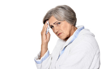 Serious senior woman with headache, isolated on white