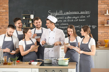 Male chef and group of young people during cooking classes