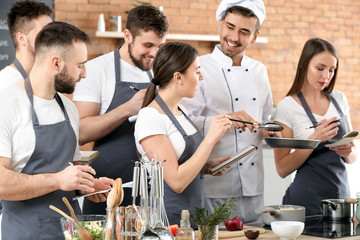 Male chef and group of young people during cooking classes