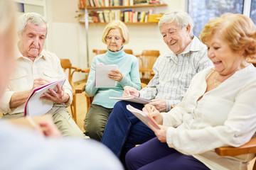 Senioren in einer Gruppentherapie beim Schreiben oder Ausfüllen von Fragebogen