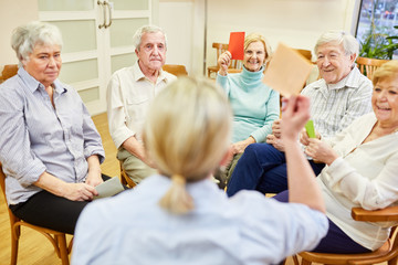 Gruppe Senioren und Therapeutin machen Gedächtnistraining mit  bunten Zetteln