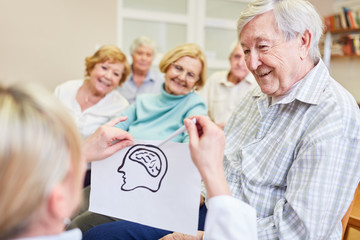Ärztin und Senioren mit einer Skizze vom Gehirn macht Gesundheit Aufklärung