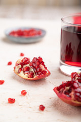 Glass of pomegranate juice on a white concrete background. Side view, selective focus