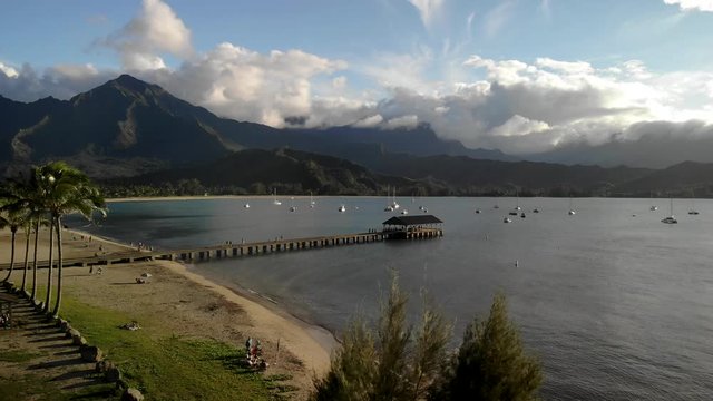 4K drone footage over Hanalei bay, Kauai, Hawaii, with Hanalei Pier and mountains in the back.
Mid angle, traveling movement.