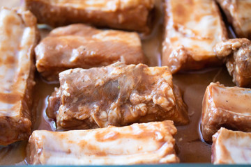Raw marinaded juicy pork ribs ready for cooking. Meat processing picture. Food photography close up background