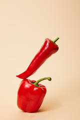 red chili pepper on bell pepper on beige