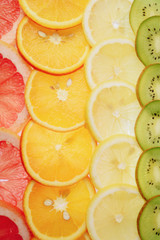 Fototapeta na wymiar translucent slices of lemon, orange, kiwi and grapefruit on a white background, citrus fruit slices, summer mix