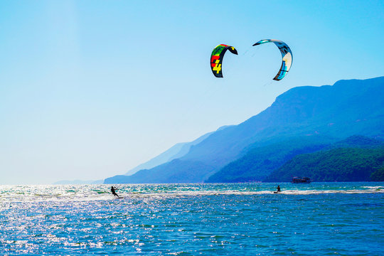 Akyaka, Mugla/Turkey-August 14 2018: Two surfers enjoying kite surfing at the beach where Azmak River meets the Mediterranean Sea