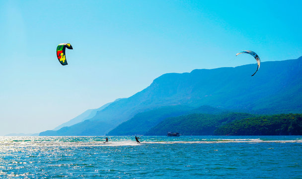 Akyaka, Mugla/Turkey-August 14 2018: Two surfers enjoying kite surfing at the beach where Azmak River meets the Mediterranean Sea