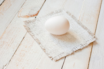 White chicken eggs lying on a white painted wooden surface. Background for livestock products.
