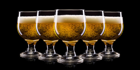 Set of frosty glasses of light beer with foam isolated on a black background