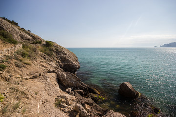 Travel in Crimea, Russia. Nature background. Colorful landscape with blue sea, mountains, rocks and sunlight in clear warm summer cloudless day. Concept of vacation on the coast