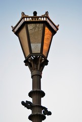 Fototapeta na wymiar Old street lamp on blue sky. Color photo taken at Saint-Petersburg, Russia.