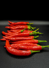 Many hot peppers on a black background