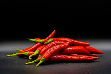 Many hot peppers on a black background