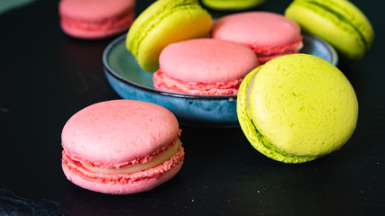 still life, pink and pistachio macaroons on a black tray