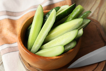 Bowl with green cucumbers on table